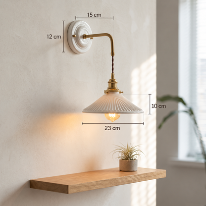 White ceramic wall sconce with brass hardware showing a 12 cm wall plate, 15 cm arm projection, 10 cm shade height and 23 cm shade width.