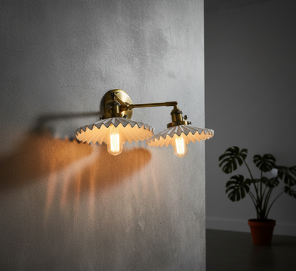 Wall-mounted lamp with gold fixture and textured glass shade on a gray wall.
