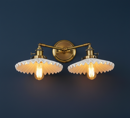 Pair of wall-mounted lights with gold fixtures and white glass shades on a dark blue background.
