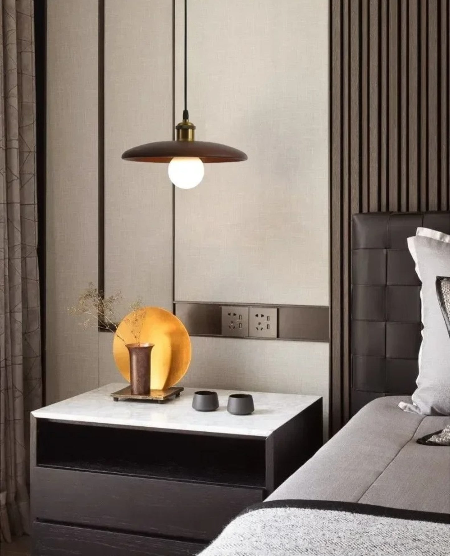 Modern bedroom with a nightstand, lamp, and decorative items.