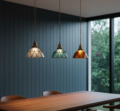 Three pendant lights hanging above a wooden table with a blue paneled wall and window in the background.